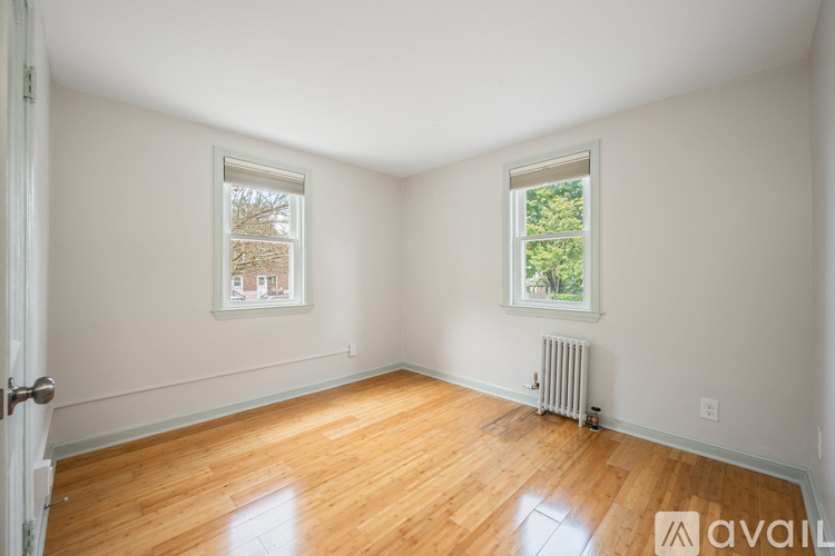 A room with wooden floors and two windows.