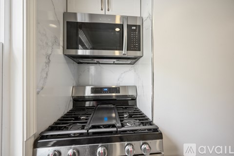 A modern kitchen with a stainless steel stove and microwave above it.
