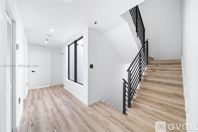 A staircase with wooden steps and a black railing.