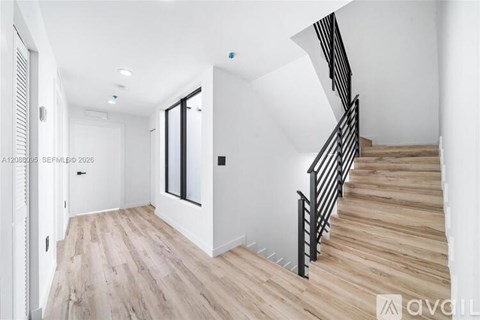 A staircase with wooden steps and a black railing.