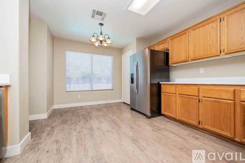A kitchen with wooden cabinets and a refrigerator.