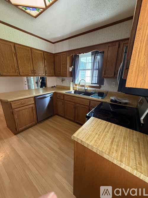 A kitchen with wooden cabinets and a stove top oven.