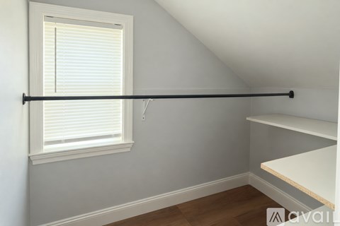 A room with a window and a shelf.