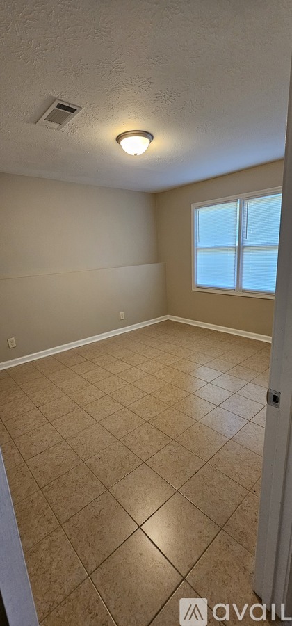 A room with beige walls and tile flooring.