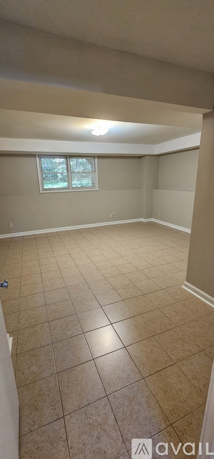 A room with beige walls and tiled flooring.