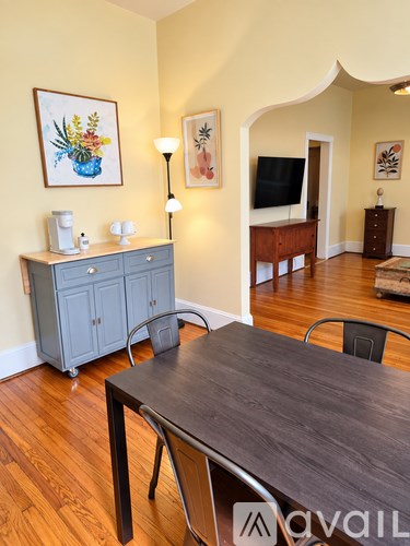 A dining room with a wooden table and chairs.
