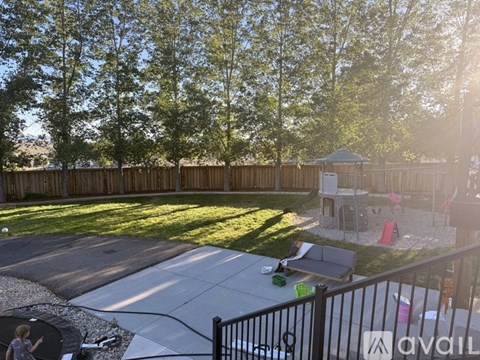 A backyard with a trampoline and a gazebo.