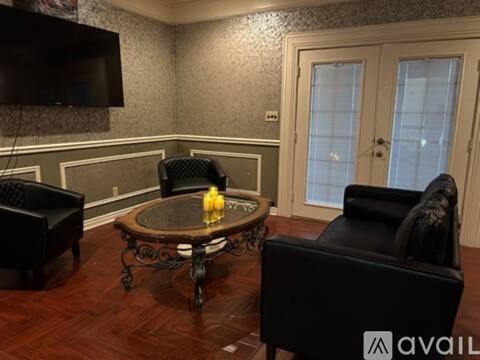 A living room with a black leather chair and a coffee table.