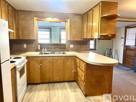 A kitchen with wooden cabinets and a white refrigerator.