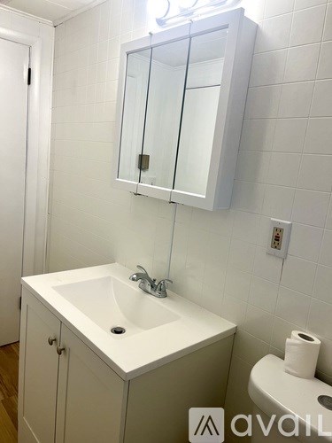 A white sink in a small bathroom with a mirror above it.