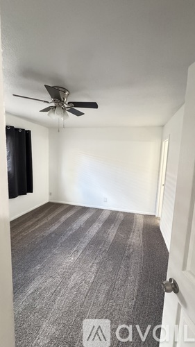 A room with a ceiling fan and a carpeted floor.