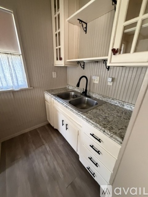 A kitchen with white cabinets and a granite countertop.
