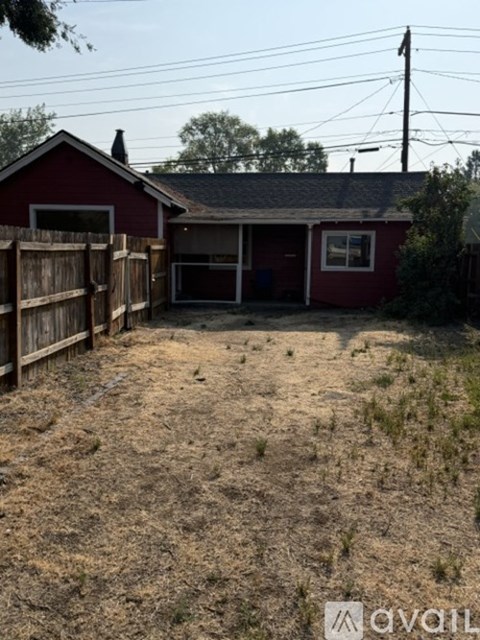 A red building with a brown fence in front of it.