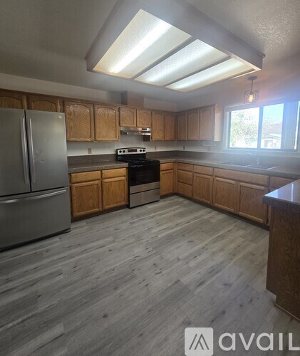 A kitchen with wooden cabinets and a grey floor.