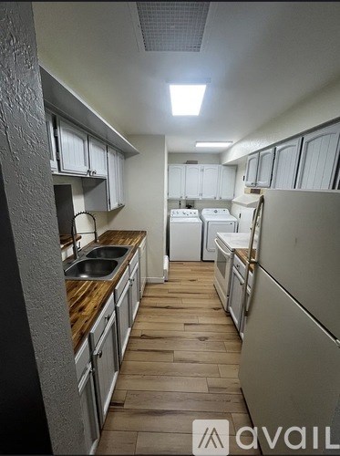 A kitchen with wooden floors and white appliances.