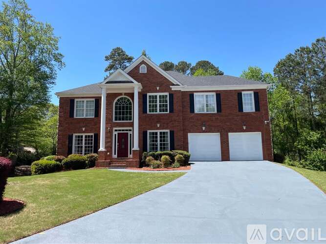 A brick house with a driveway in front.