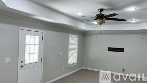 A room with a ceiling fan and a door.