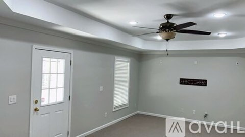 A room with a ceiling fan and a door.