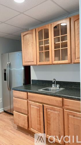 A kitchen with wooden cabinets and a black countertop.