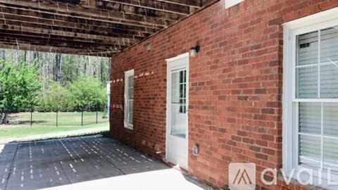 A brick building with a white door and window.