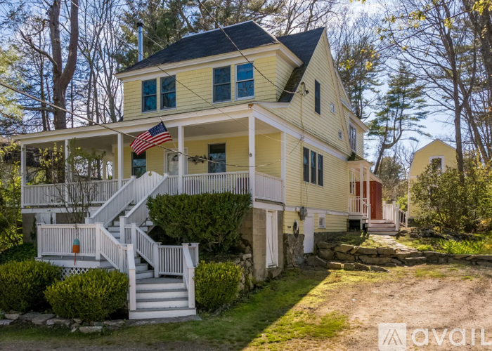 A yellow house with a flag on the porch.