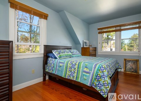 A bedroom with a bed and a window.
