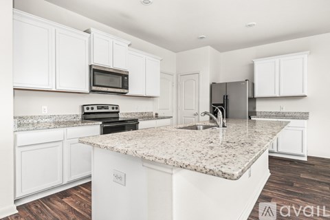A kitchen with white cabinets and a granite countertop.