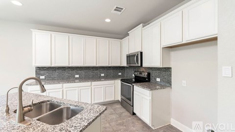 A kitchen with granite countertops and white cabinets.