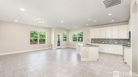 A spacious kitchen with white cabinets and a central island.