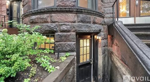 A stone building with a black door and windows.