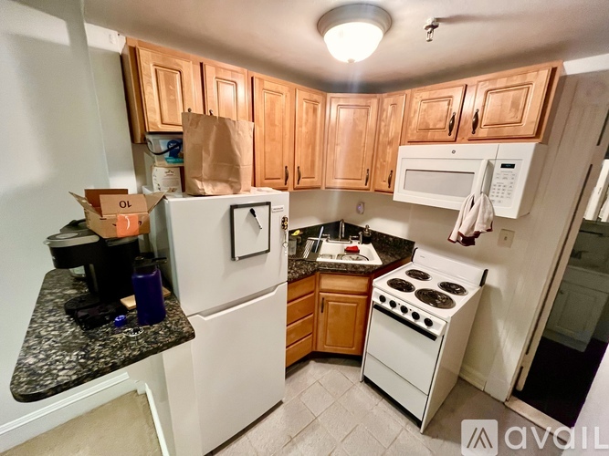 A kitchen with white appliances and wooden cabinets.