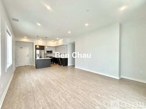 A spacious room with a kitchenette and a dining table is ready for decoration.