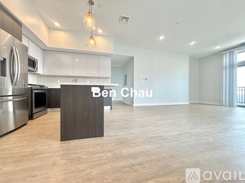 A modern kitchen with a wooden island and a sign that says "Ben Chau".