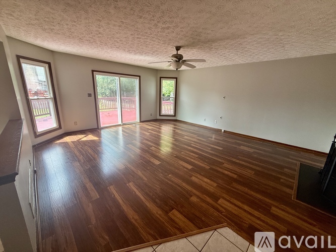 A room with wooden flooring and a ceiling fan.