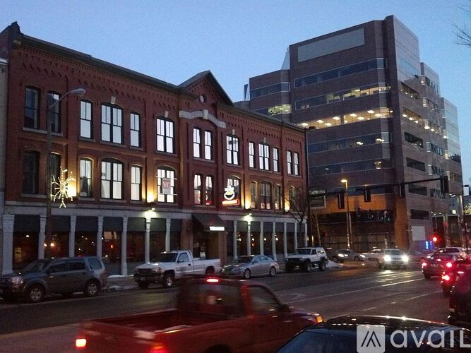 Cars are driving on a street with a building in the background.