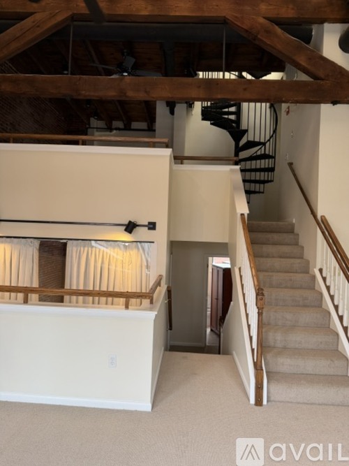 A staircase with a carpeted runner and wooden banister.