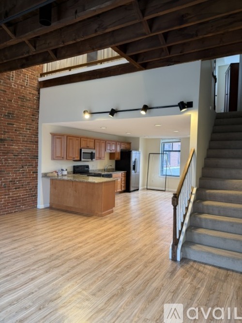 A large open space with wooden floors and a staircase leading to the upper level.