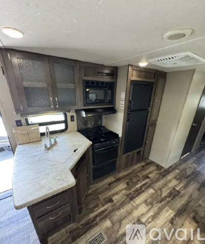 A kitchen with a white counter top and wooden cabinets.