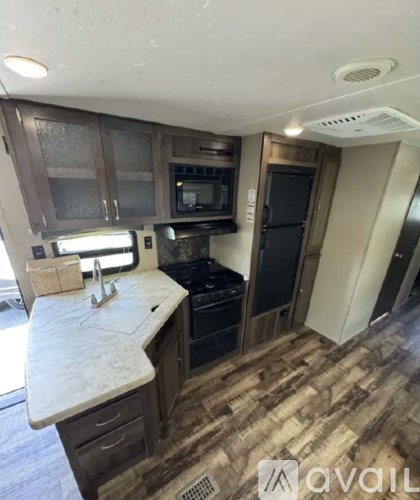 A kitchen with a white counter top and wooden cabinets.
