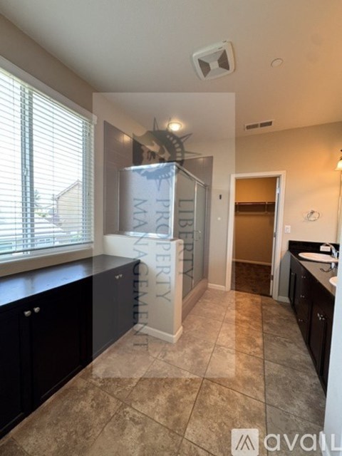 A kitchen with a glass door cabinet and a tiled floor.