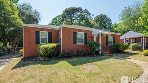 A red brick house with a white door and windows.