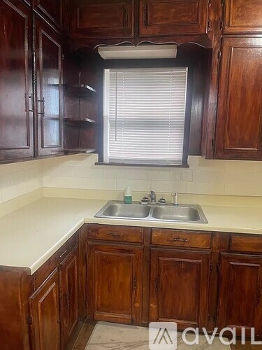 A kitchen with wooden cabinets and a white sink.