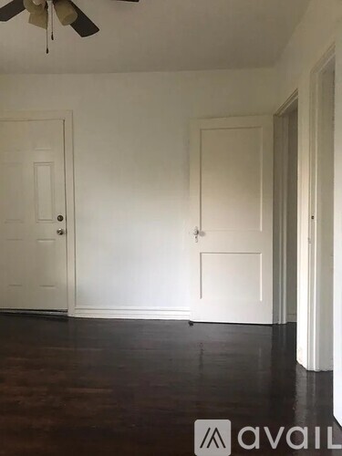 A room with a ceiling fan and two doors.