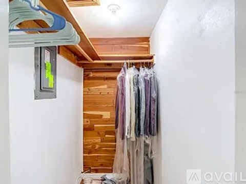A row of clothes hanging on a rack in a room.