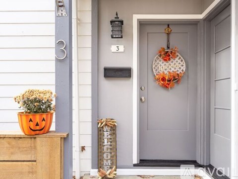 A grey door with a wreath and a sign that says "welcome".