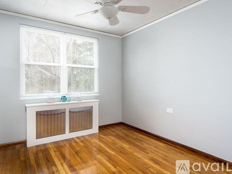 A room with a window and a fan on the ceiling.