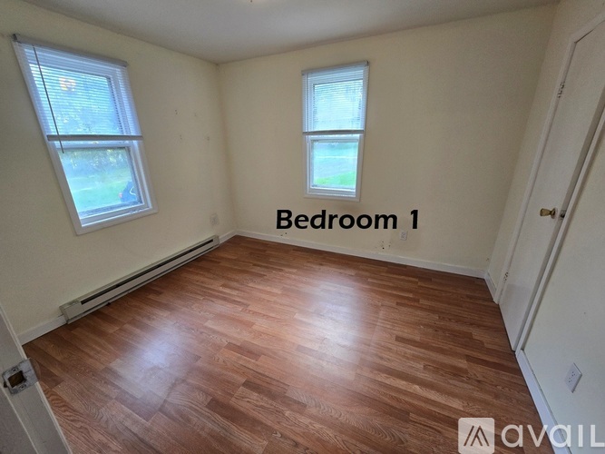Bedroom 1 has two windows and hardwood floors.