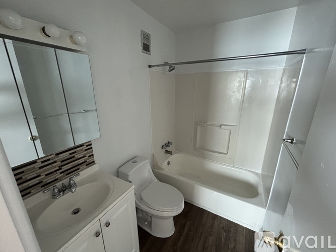 A white bathroom with a toilet, sink, and bathtub.