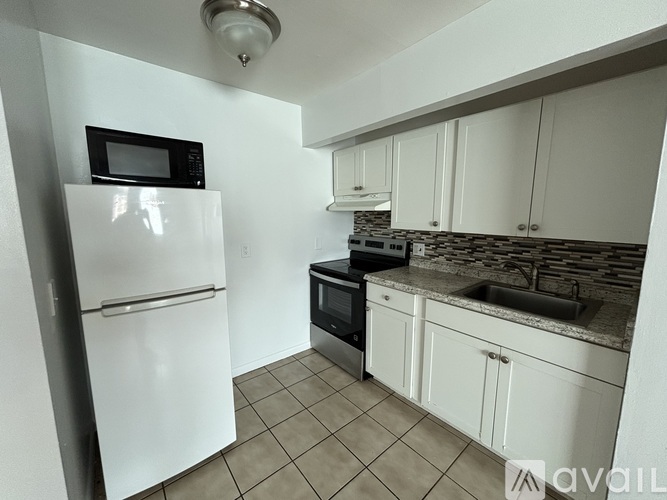 A kitchen with white appliances and cabinets.