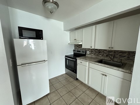 A kitchen with white appliances and cabinets.